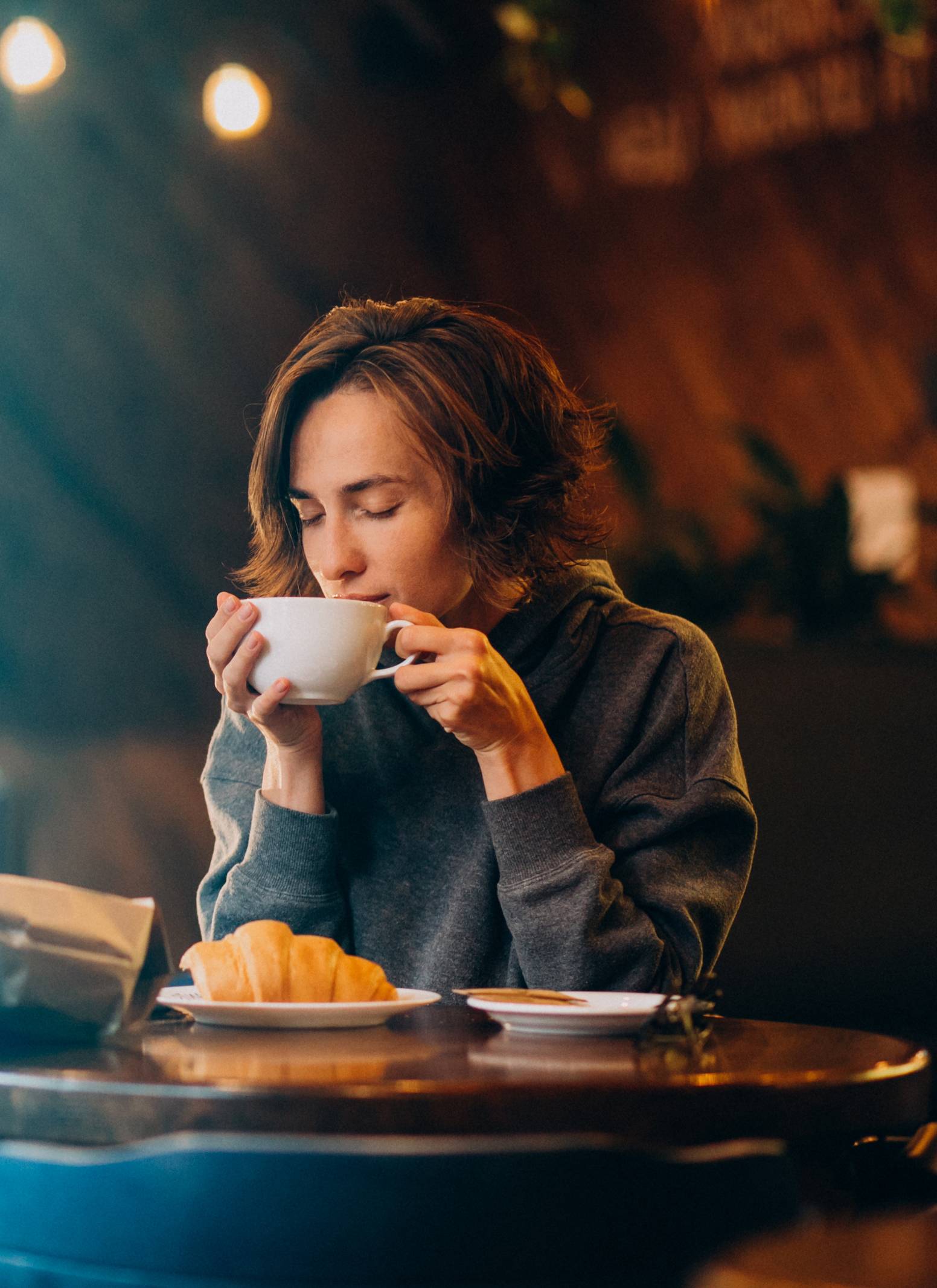 Young Woman Eating Croissants